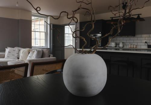 a white vase sitting on top of a table at Bath Street Penthouse in Bath
