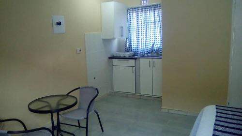een kleine keuken met een tafel en stoelen in een kamer bij Mosas Home in Serowe