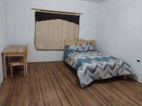 1 dormitorio con cama y escritorio de madera en Terranova en Cuenca