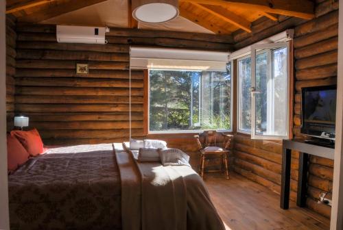 um quarto com uma cama num quarto com paredes de madeira em El Rodeo Apart Cabañas em Santa Rosa de Calamuchita