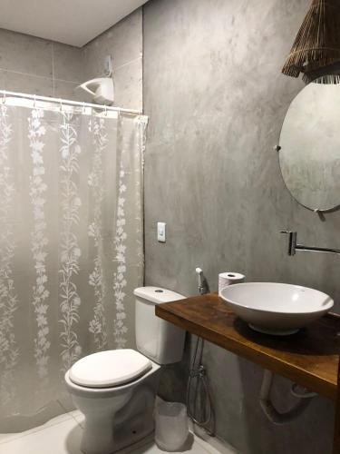 a bathroom with a white toilet and a sink at Suite Economica Wind Jeri in Jericoacoara