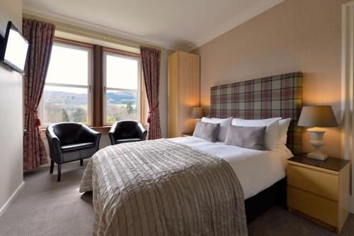 a hotel room with a bed and a large window at The Poplars Guest House in Pitlochry