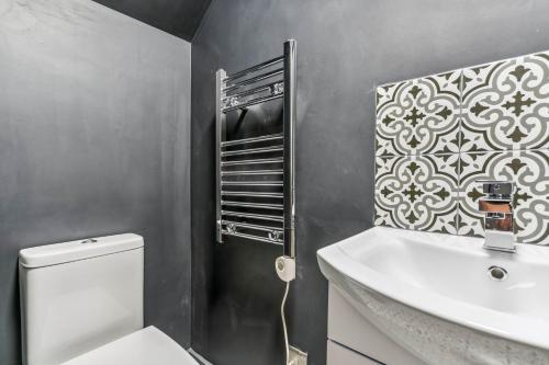 een badkamer met een wit toilet en een wastafel bij Cozy London Apartment in Londen
