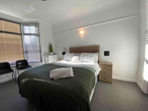 um quarto com uma cama grande e uma secretária em Silver Stag Properties, 4 BR Perfect for Groups em Hugglescote