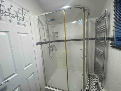 La salle de bains est pourvue d'une douche avec une porte en verre. dans l'établissement Silver Stag Properties, 4 BR Perfect for Groups, à Hugglescote