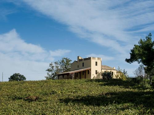 an old house on top of a grassy hill at Masseria del Vino in Loreto Aprutino