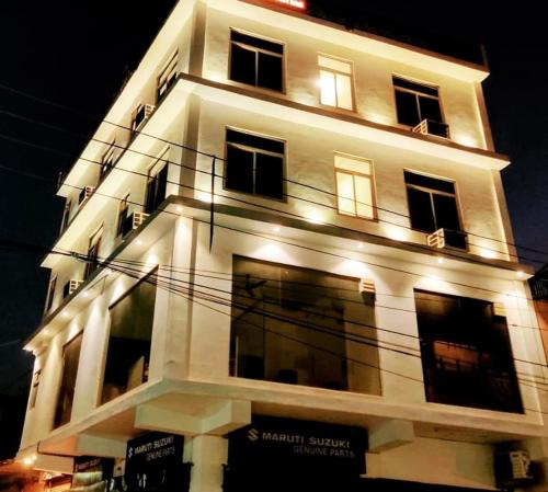 een hoog wit gebouw met lichten erop bij Hotel Pearl inn in Rudrapur