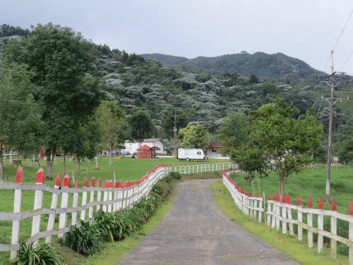 a road in a field with a white fence at Hotel Recreacional Marcelandia Santa Rosa de Cabal in Santa Rosa de Cabal