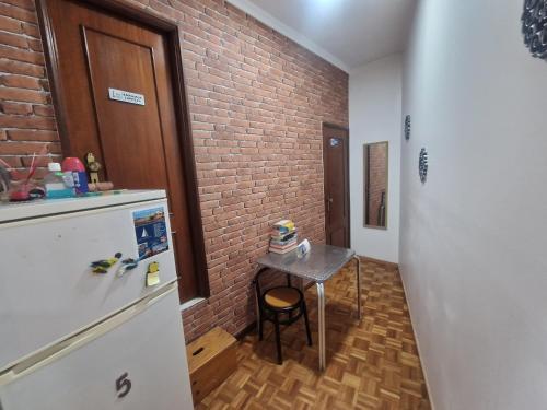 a kitchen with a small table and a brick wall at Truz truz2 in Porto