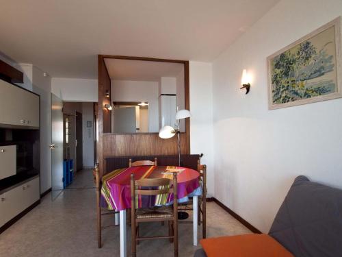 Cette chambre comprend une table avec des chaises et un miroir. dans l'établissement Appartement avec Balcon - Plage à 150m, Parking - FR-1-92-639, à Les Sables-dʼOlonne