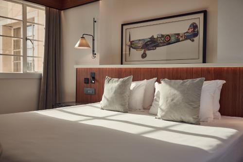 a bedroom with a large bed with white pillows at Melia White House Hotel in London