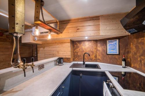 a kitchen with a sink and wooden walls at Houseboat GDY-50, dom na wodzie z sauną i jacuzzi in Puck