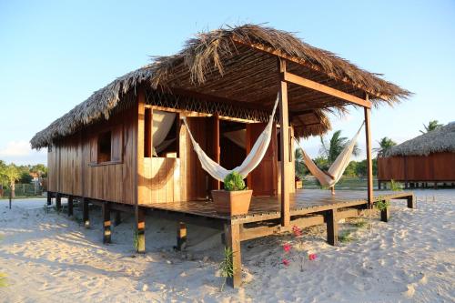 een kleine hut met een rieten dak op een strand bij Vila Guará in Atins