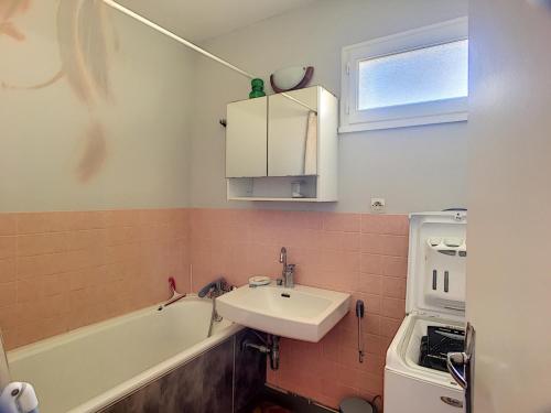 une salle de bain avec un lavabo et une baignoire dans l'établissement Maison de plain-pied avec jardin, à 200m de la plage et 400m des commerces - FR-1-361-58, à Jullouville