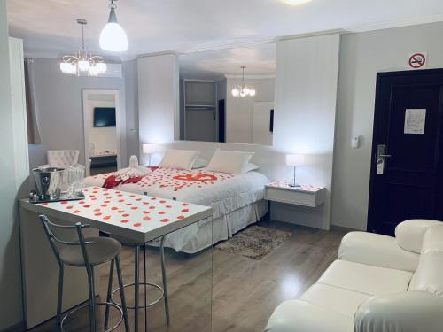 a bedroom with a bed and a table and chairs at Olinda Hotel e Eventos in Toledo