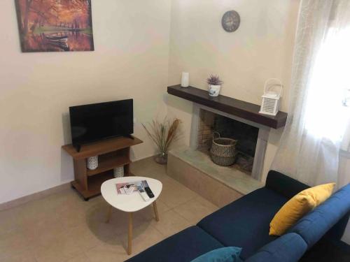 a living room with a blue couch and a fireplace at g&z cottage in Kynopiástai