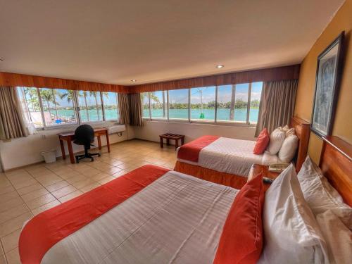 Habitación de hotel con 2 camas y ventana grande. en Best Western Riviera Tuxpan, en Tuxpan de Rodríguez Cano