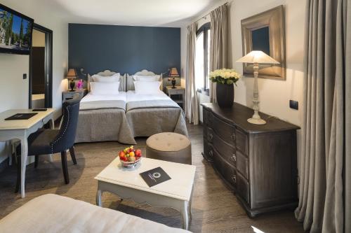 a hotel room with two beds and a desk at Hostellerie Les Gorges De Pennafort in Callas