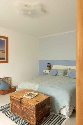 a bedroom with a bed with a wooden trunk next to it at VITEDIMARE APARTMENT SABBIA - SAND in Muggia