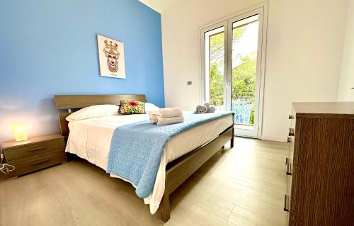 a bedroom with a bed with blue walls and a window at Villa Cavagrande in Avola