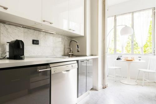 cocina blanca con fregadero y lavavajillas en Pirelli - Flexyrent WiFi - A.C., en Milán
