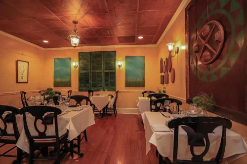 The Charlotte Hotel & Restaurant في Onancock: مطعم به طاولات وكراسي به مفارش بيضاء