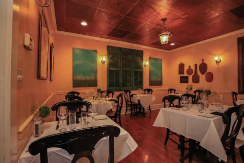 un restaurante con mesas y sillas blancas en una habitación en The Charlotte Hotel & Restaurant, en Onancock