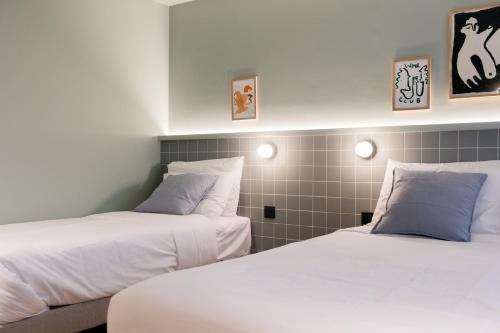 two beds sitting next to each other in a room at Maison Arya in Brussels