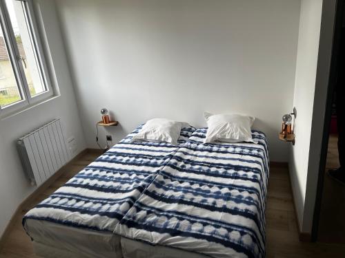 Bresles的住宿－Le château d’eau，床上有蓝色和白色的毯子