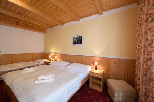 a bedroom with two beds and two lamps on two tables at Sport-V-Hotel in Hrotovice