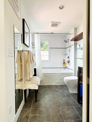 a bathroom with a tub and a toilet and a sink at Northey Street House in Salem