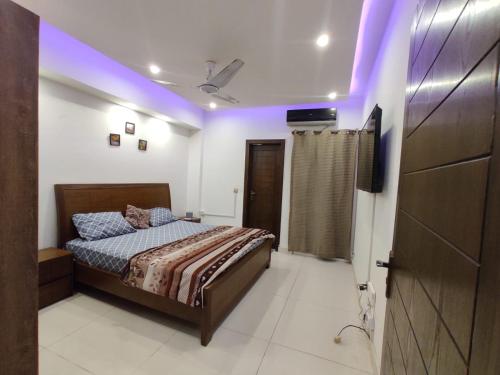 een slaapkamer met een bed en een paars licht bij New & elegant 1BR Flat for Families,tourists,4k Netflix,wifi,E11 Markaz in Islamabad