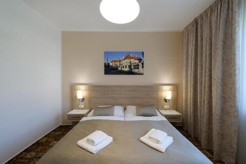 a bedroom with a large bed with two towels on it at Sport-V-Hotel in Hrotovice