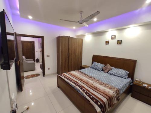 een slaapkamer met een bed en een badkamer bij New & elegant 1BR Flat for Families,tourists,4k Netflix,wifi,E11 Markaz in Islamabad