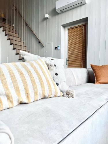 un divano bianco con cuscini in una stanza di Wind Shelter Svencele a Svencelė