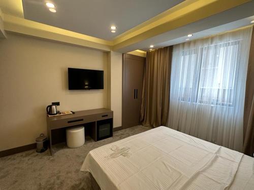 pokój hotelowy z łóżkiem i telewizorem w obiekcie Istanblu Hotel Ataşehir w Stambule