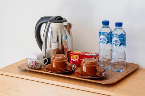 a tray with cups and bottles of water on a table at Tegal Sari Cabin Kintamani in Kintamani