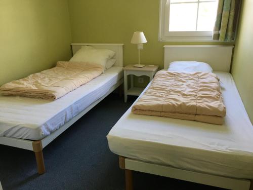 dwa łóżka w pokoju z oknem w obiekcie Maison Fort-Mahon-Plage, 3 pièces, 4 personnes - FR-1-482-39 w mieście Fort-Mahon-Plage