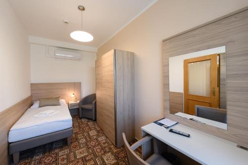 a small hotel room with a bed and a desk at Sport-V-Hotel in Hrotovice