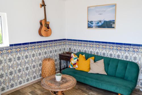 a living room with a green couch and a guitar at Olympo Shared flat with Amazing River view in Lisbon