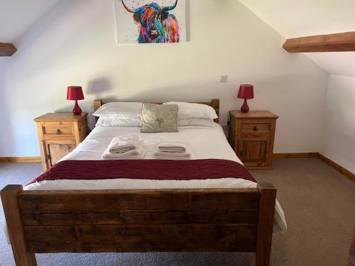 um quarto com uma cama grande e 2 mesas de cabeceira em White House Farm Cottages em West Haddon