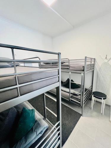 Zimmer mit 2 Etagenbetten und einem Stuhl in der Unterkunft Neuwertiges Apartment mit schnellem WLAN, Glasfaser, Kostenlose Privatparkplatz auch für Transporter geeignet R21 in Freiberg am Neckar