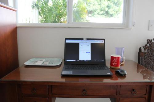 a laptop computer sitting on top of a wooden desk at Dancing Iguanas in Eagle Beach