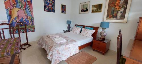 a bedroom with a bed and a painting on the wall at Dancing Iguanas in Eagle Beach