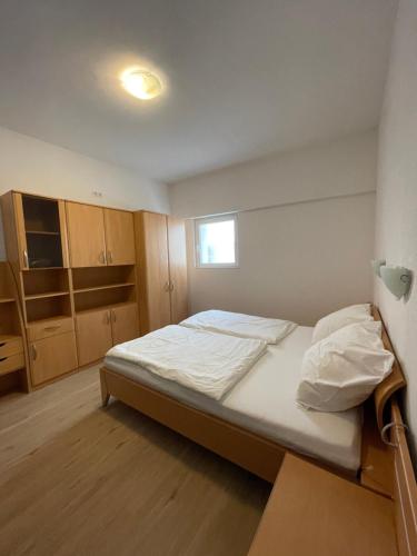 um pequeno quarto com uma cama e armários de madeira em 70qm Apartment für sie und ihre Familie 