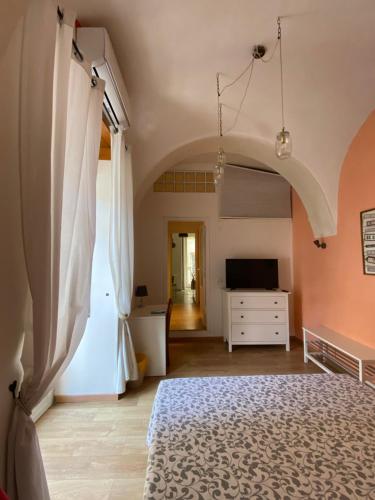 um quarto com uma cama, uma cómoda e uma televisão em In The Heart Of Naples em Nápoles