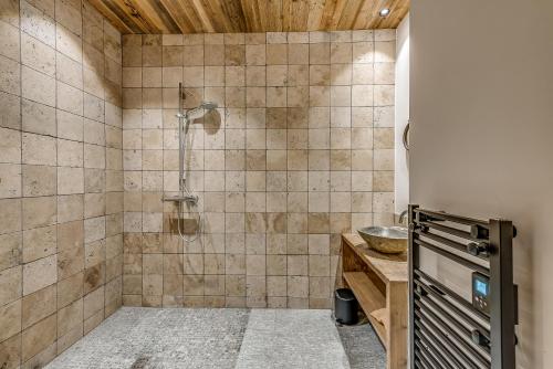 uma casa de banho com um chuveiro e um lavatório. em Appartement FORNET à l'Hôtel LE VAL D'ISERE em Val dʼIsère