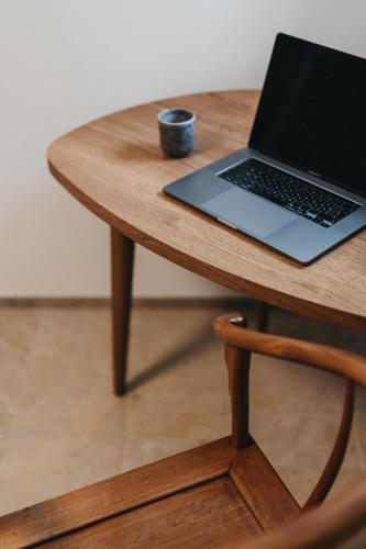 a laptop computer sitting on top of a wooden table at Das Dietrich - Landhaus 64 in Leibnitz
