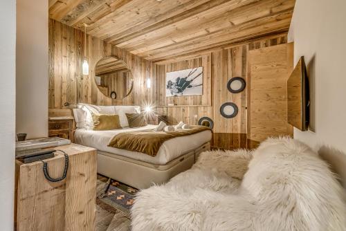 a bedroom with two beds and a mirror at Appartement FORNET à l'Hôtel LE VAL D'ISERE in Val dʼIsère