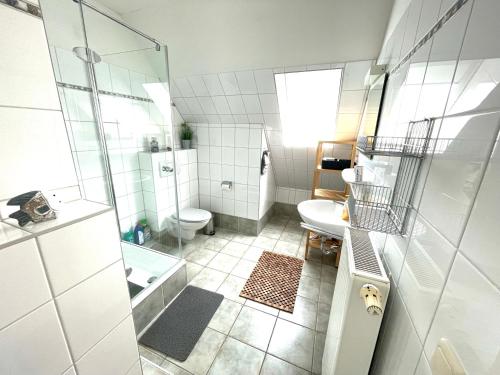 a bathroom with a shower and a toilet and a sink at Die Ostseeperle mit Pool 2 in Barendorf